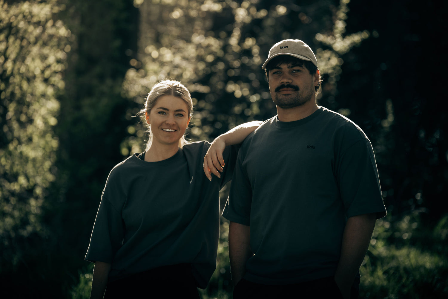 Woman and man models posing in Dark clothing in a forest